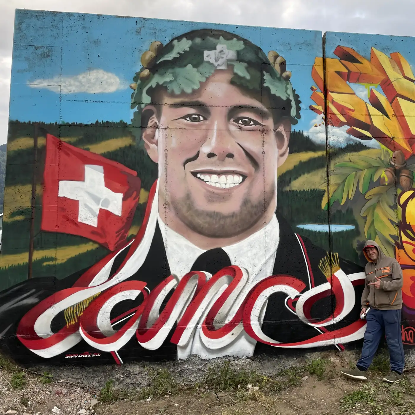 Schwinger Roger Rychen mit Schweizerfahne vor alpiner Landschaft im Hintergrund gesprayt von Graffiti-Künstler Patrick Artho, Ostschweiz